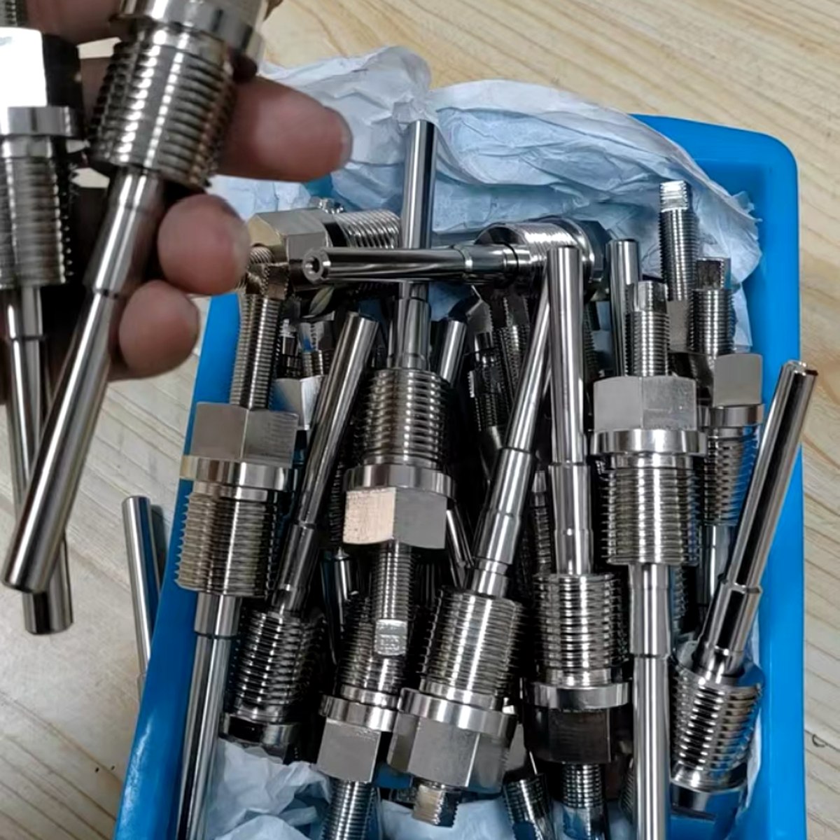 CNC machined sensor fittings in production tray — EKINSUN batch turning