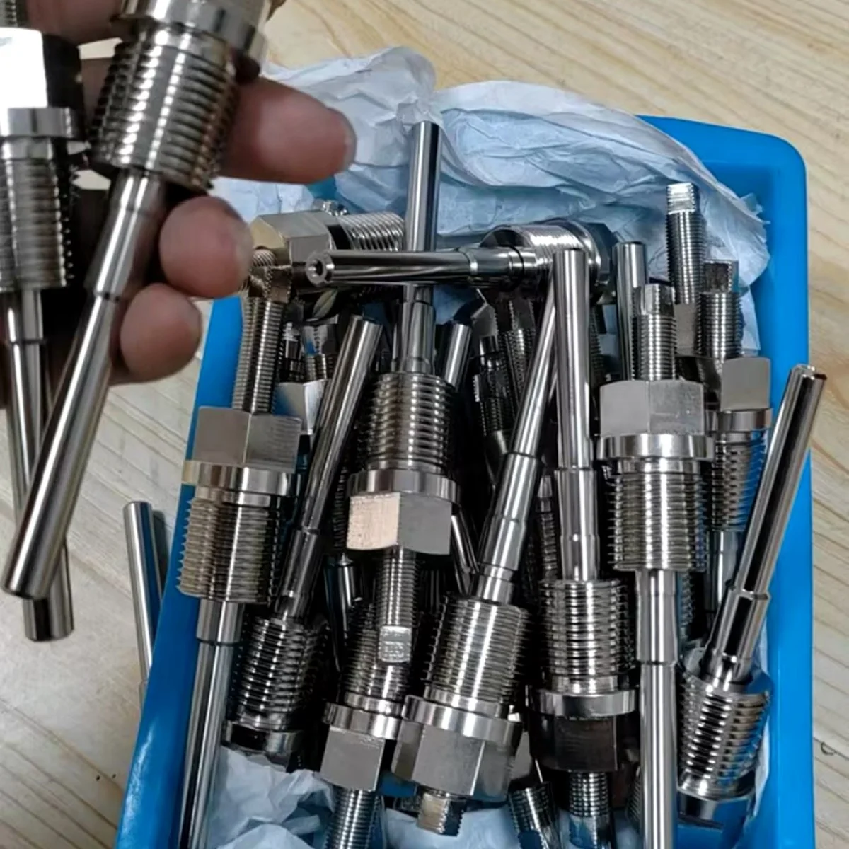 CNC machined sensor fittings in production tray — EKINSUN batch turning